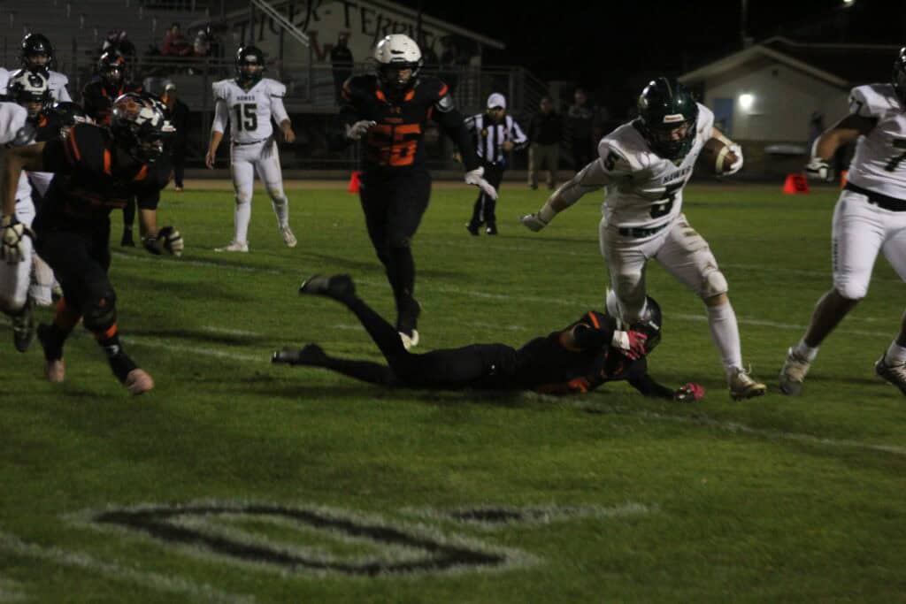 Wasco rushing attack stops Hawks player during game night.