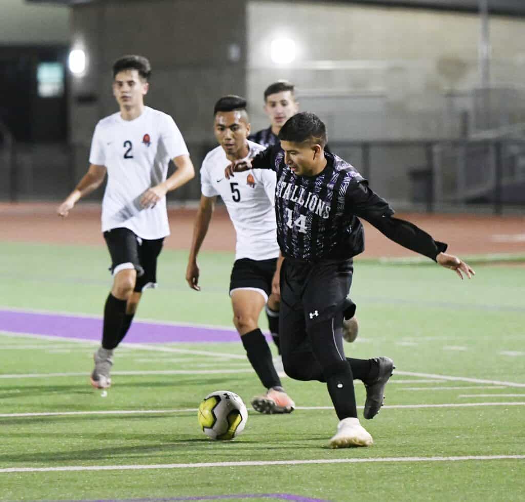 Stallions soccer players competing fiercely during a game against Merced.