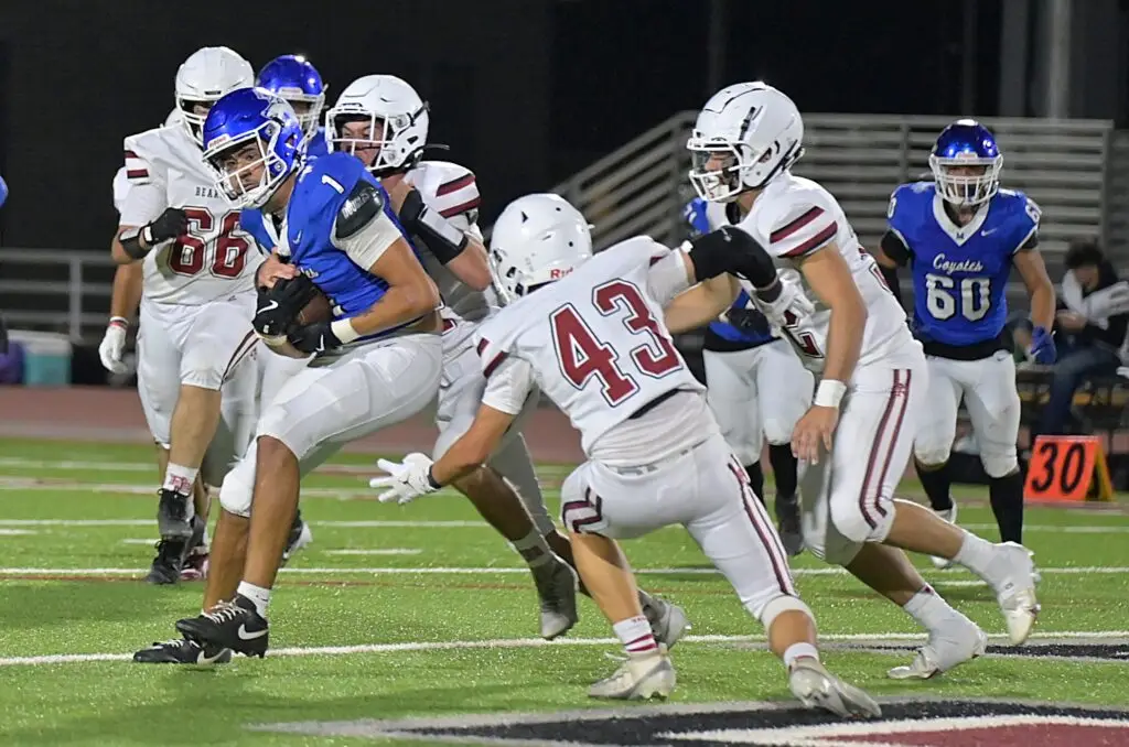 Photo - Madera’s Jayden Martinez fights for extra yards during Friday’s victory over Paso Robles. Martinez caught five passes for 117 yards in the win.