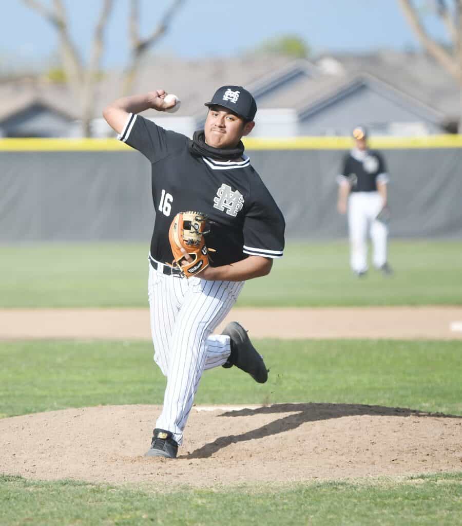 Young baseball player pitching on the mound during a game.