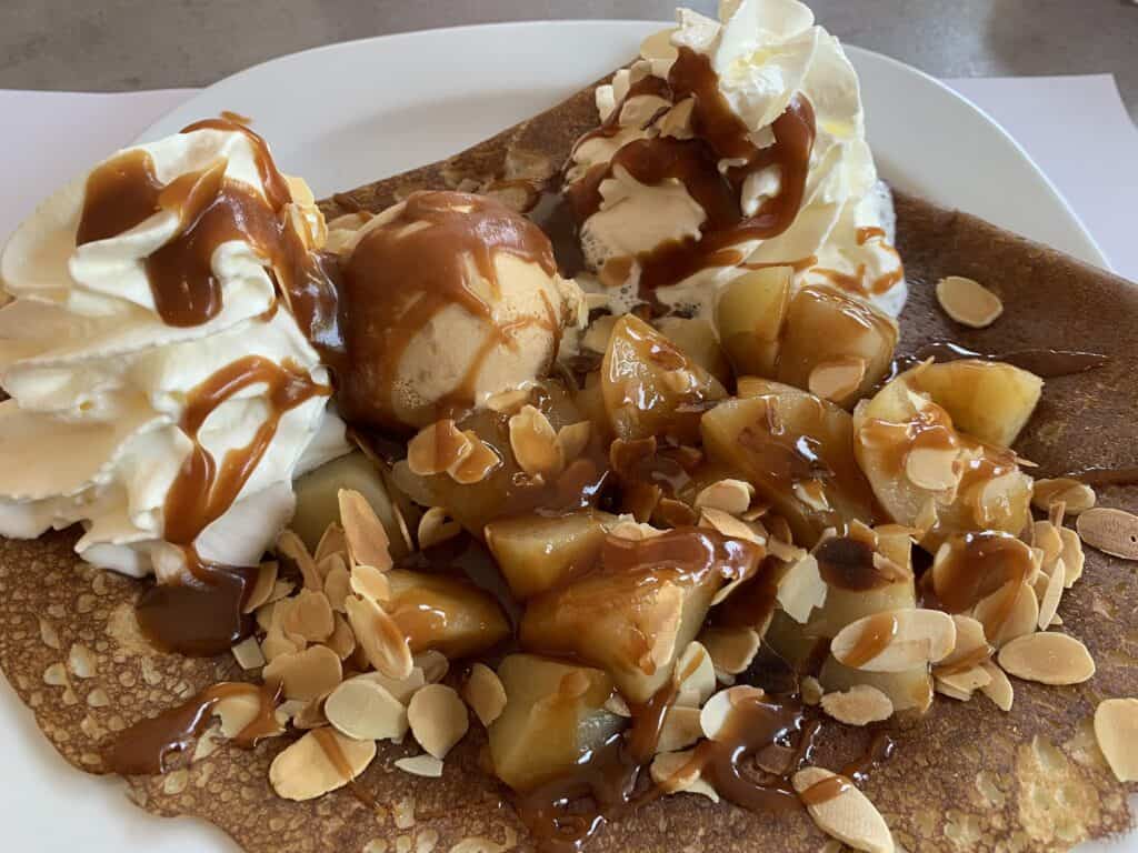 Sweet crepes topped with ice cream, caramel, and sliced almonds.