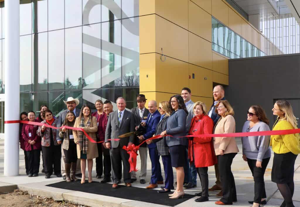 Group of people at ribbon-cutting ceremony for new academic building at MCC.