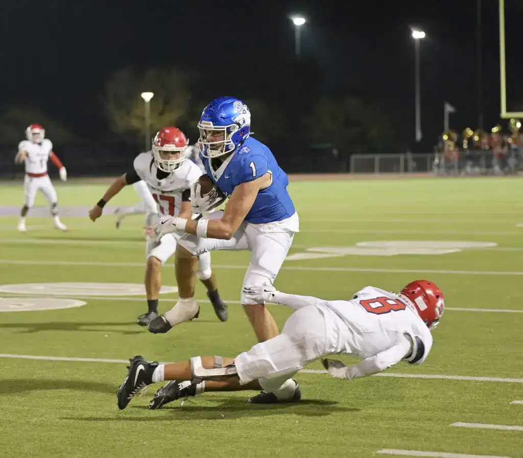 Photo - Madera’s Jayden Martinez steps over a Sanger defender during his two-yard second quarter touchdown run in Friday’s 46-28 loss to the Sanger Apaches.