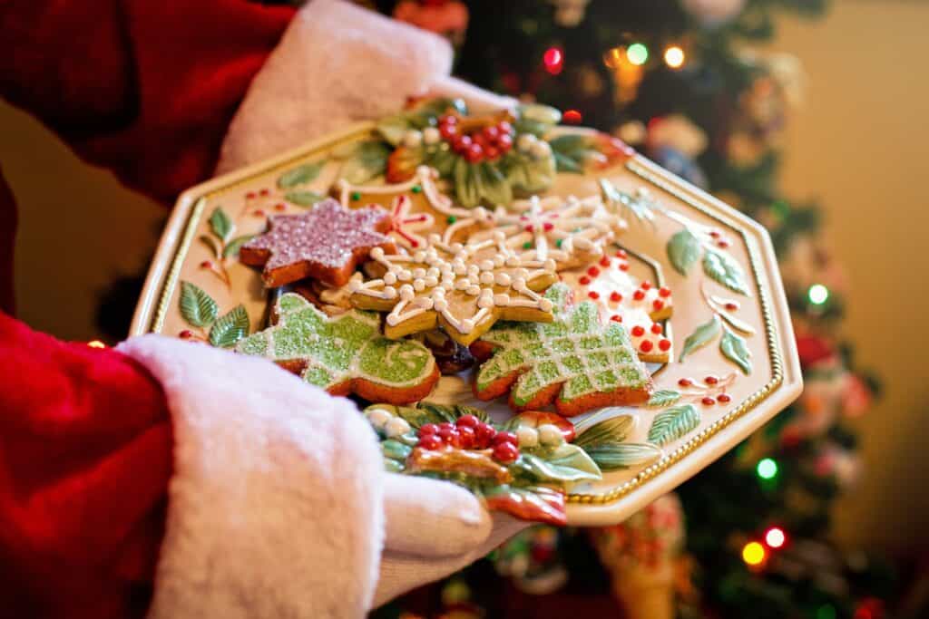 Christmas cookies displayed on a decorative plate with holiday decorations in the background.