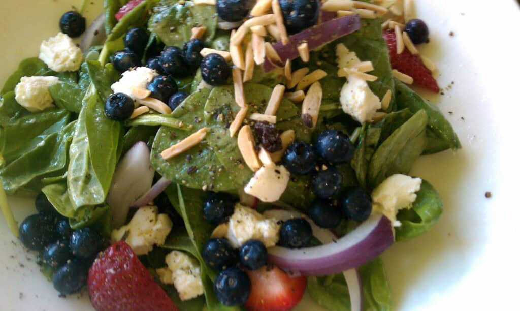 Fresh berry and spinach salad with cheese and almonds.