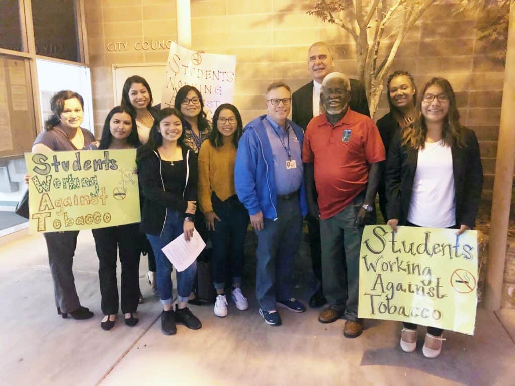 An image of Madera city officials and students protesting against tobacco at a council meeting.