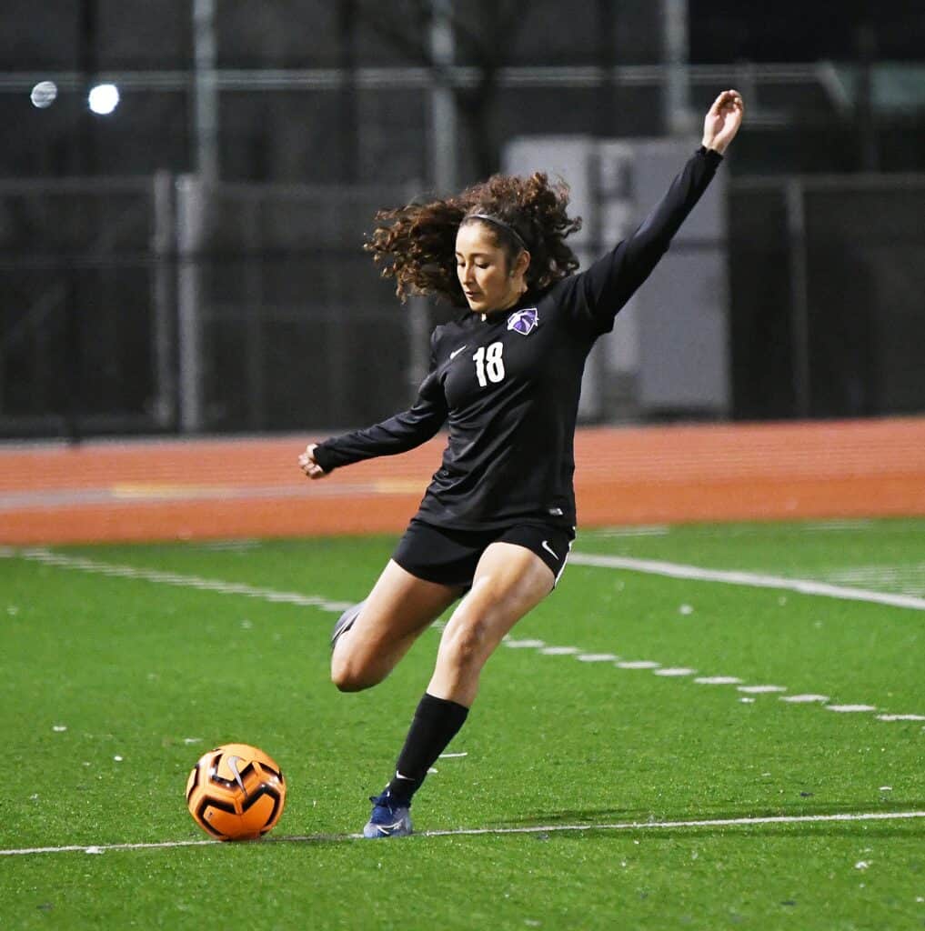 Female soccer athlete in action on the field.