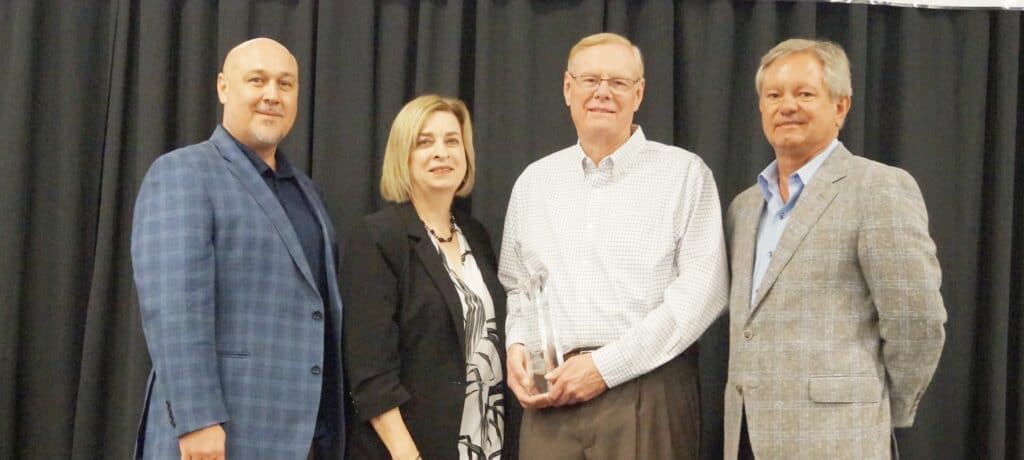 Local business receiving award for school partnerships at Madera event.