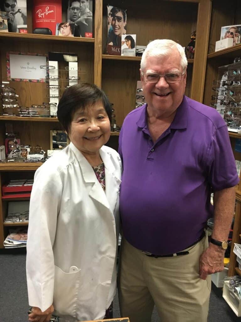Older man and woman smiling in eyewear store.