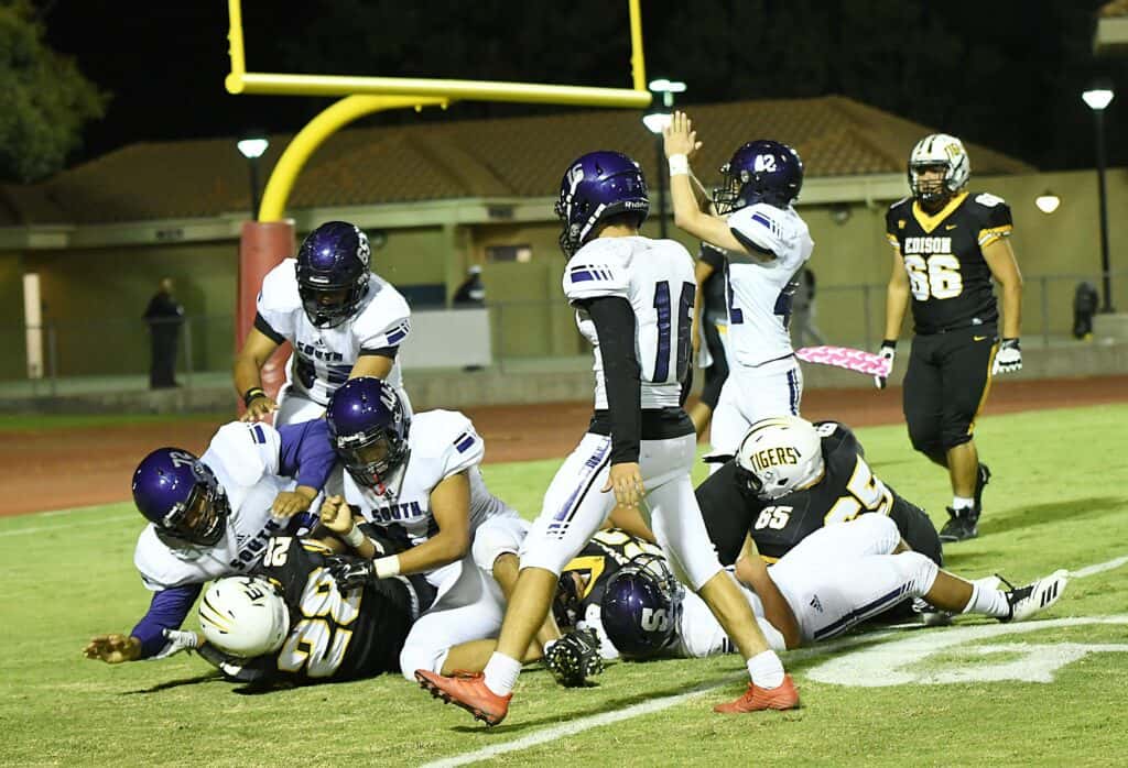 High school football players from the Stallions team celebrate a touchdown near the goalpost at CMAC.