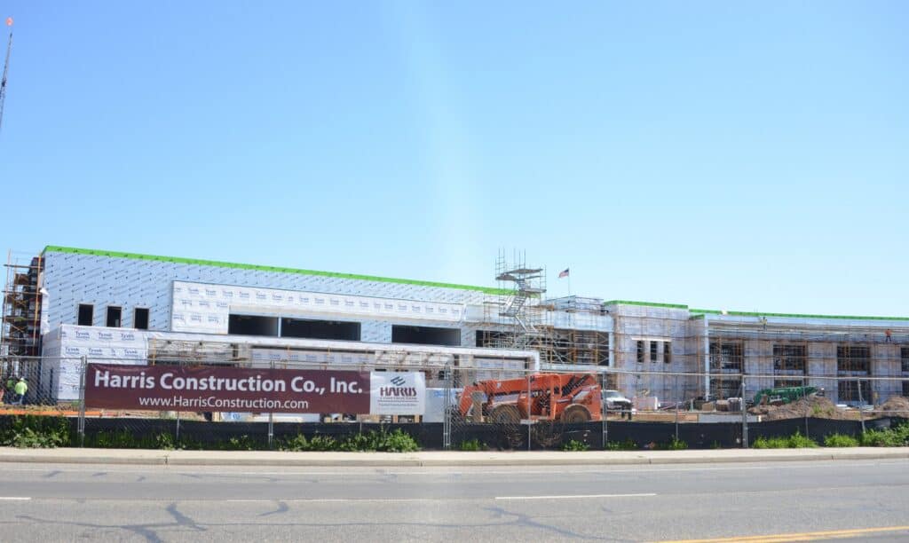 Construction site of a new K-8 school in Madera with scaffolding and building materials.
