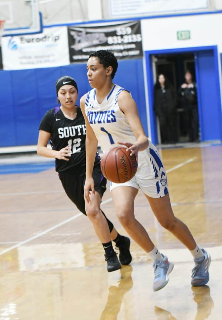 Female basketball player dribbling during game against Stallions.