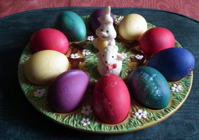 Vibrant Easter eggs in various colors with bunny decorations for spring celebration.