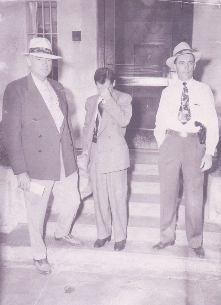 Historical photo of three individuals outside a building related to Hwy 41 execution case.