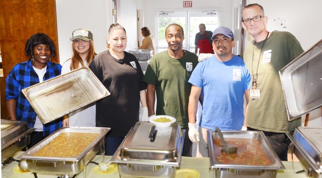Volunteers preparing and serving soups and desserts for a community charity event.