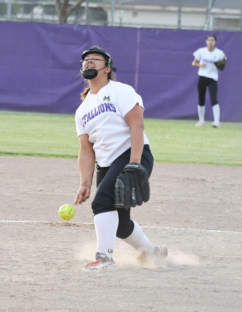 Female softball player celebrating after a successful play on the field.