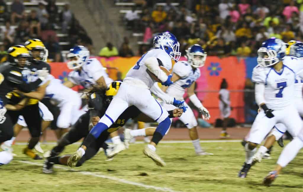 Madera Coyotes football players in action during a game.