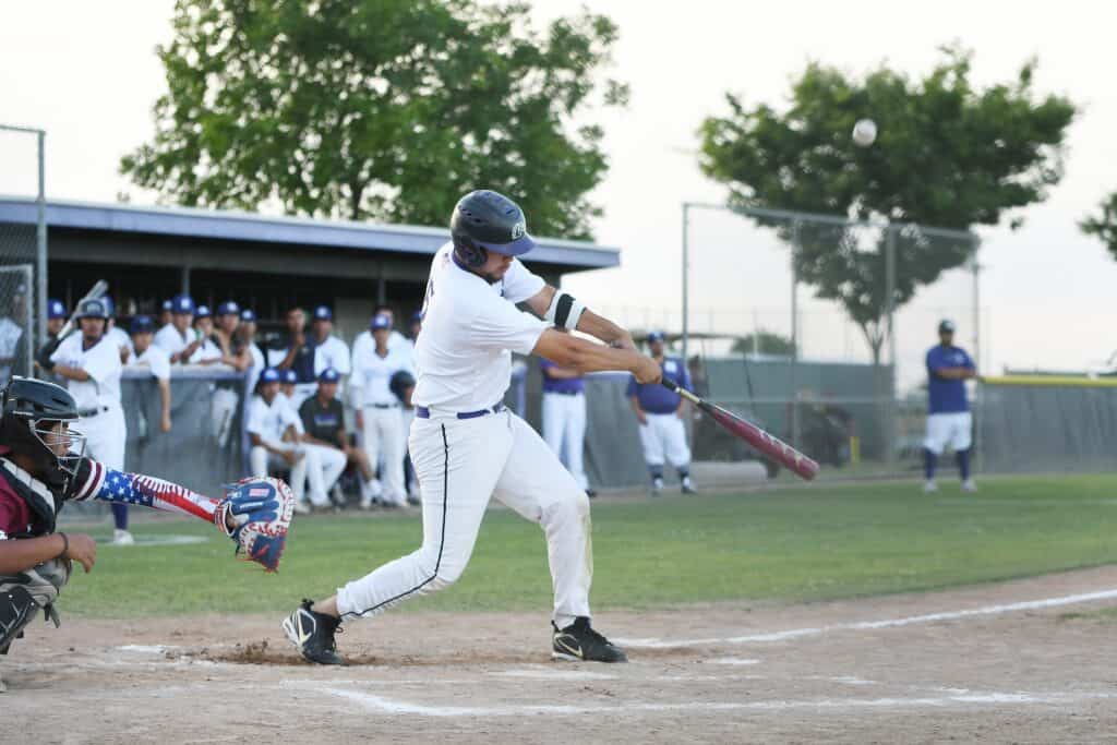 Young baseball player swinging at pitch during a neighborhood game.