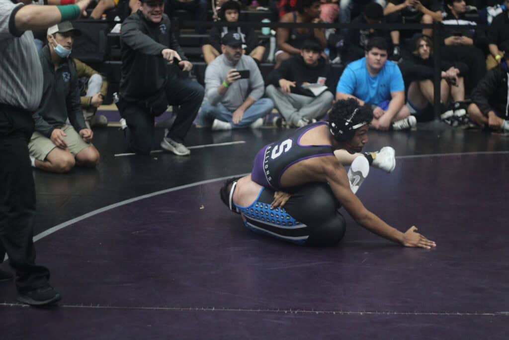 Wrestler competing in Chukchansi wrestling event, surrounded by spectators.