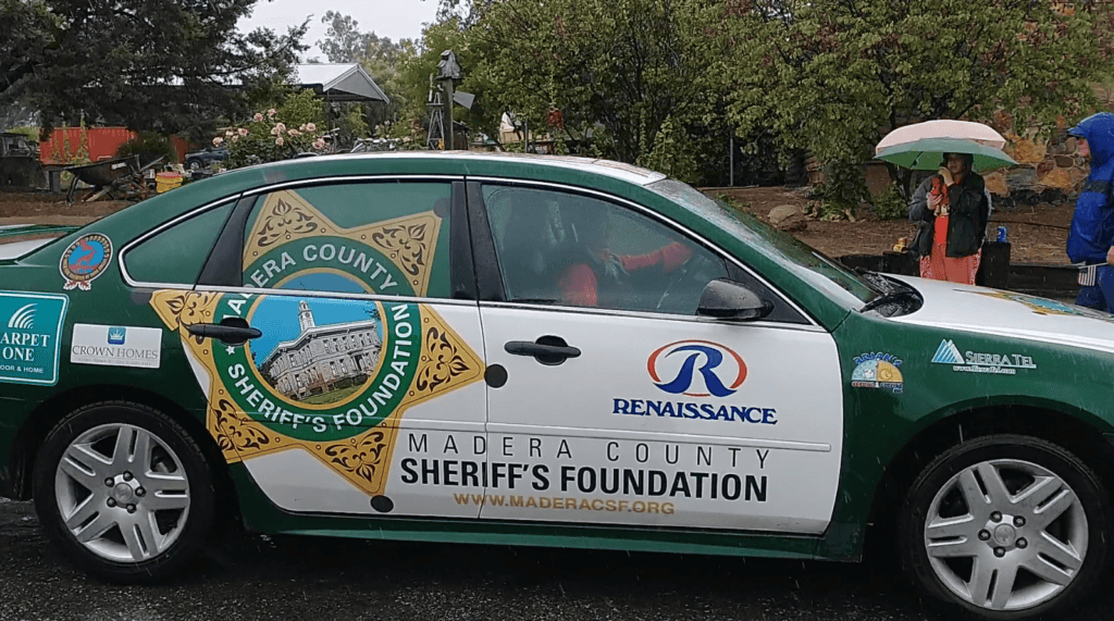Honoring first responders during Raymond parade with Madera County Sheriff's Foundation vehicle disp.