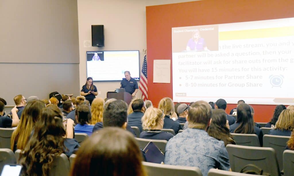 Audience attending a community event presentation in a conference room.