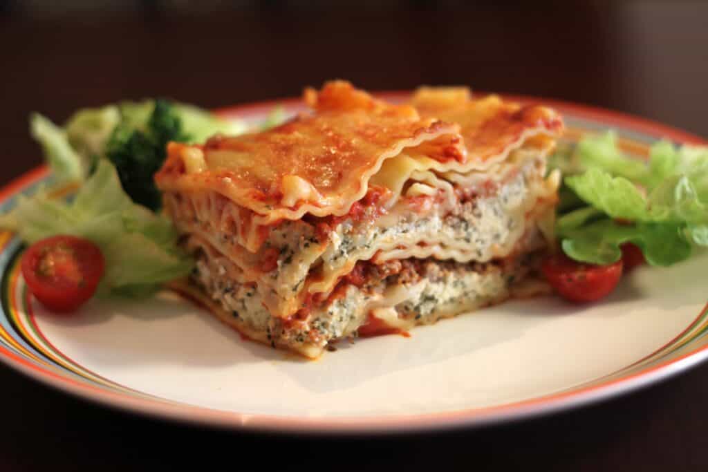 Delicious ricotta lasagna served with fresh greens and cherry tomatoes.