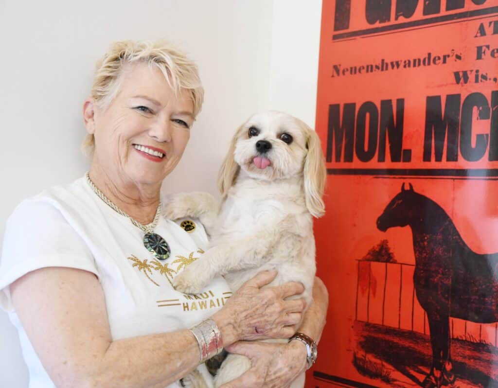 Madera animal shelter volunteer holding a dog at community event.