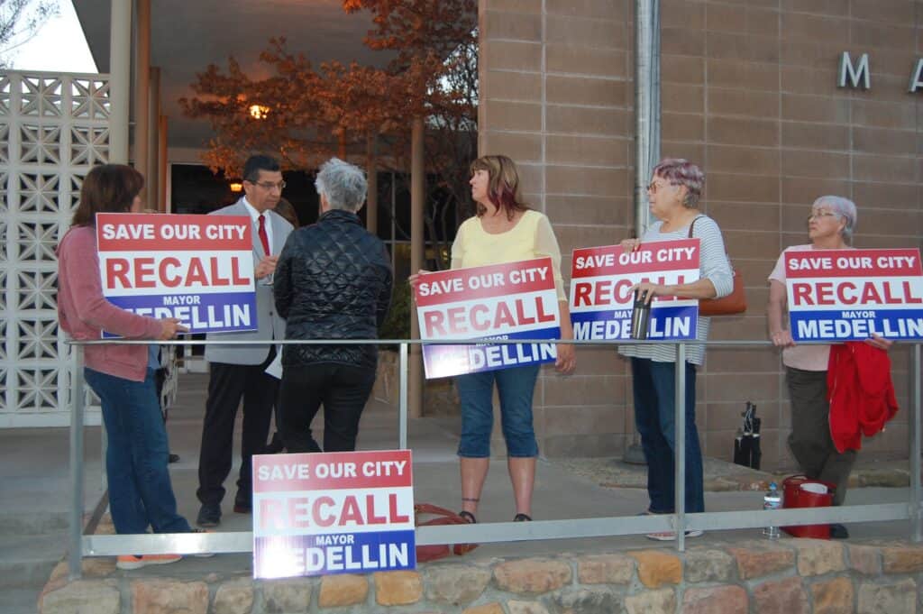Photo - Mayor Andy Medellin, speaks with Velvet Rhoads (back to camera) and other protesters calling for Medellin’s recall outside City Hall on Wednesday night.