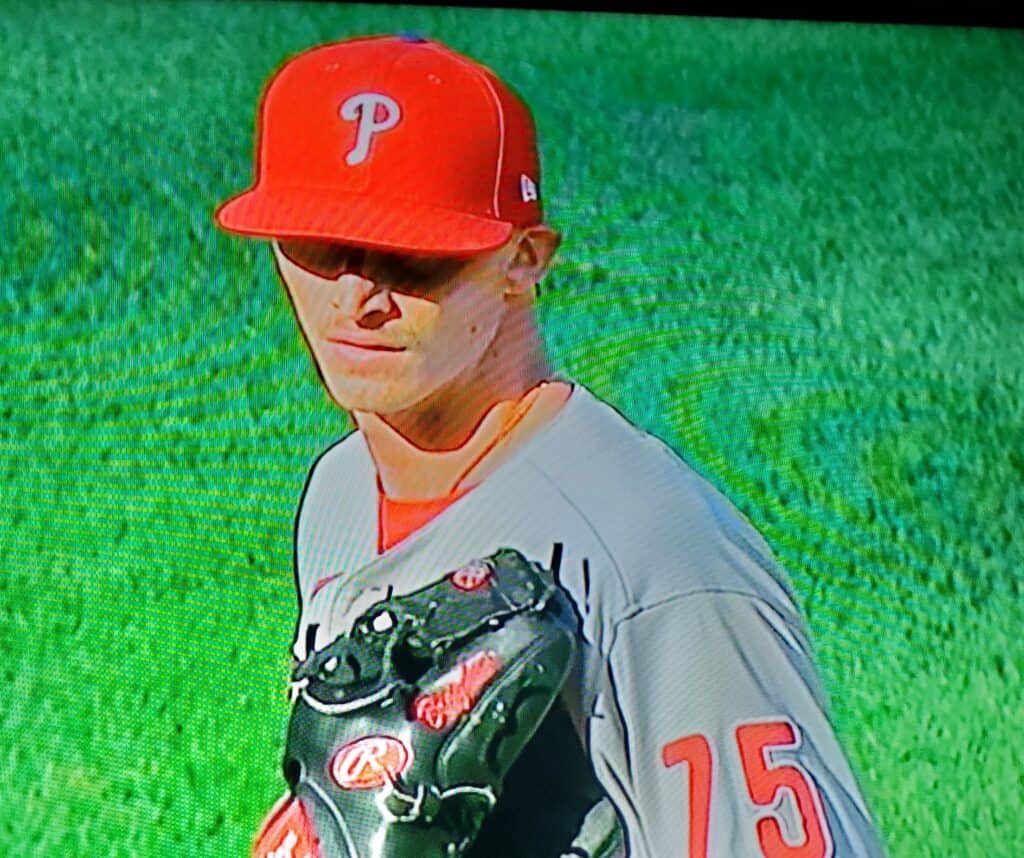 Baseball player Brogdon in uniform with glove on green field.