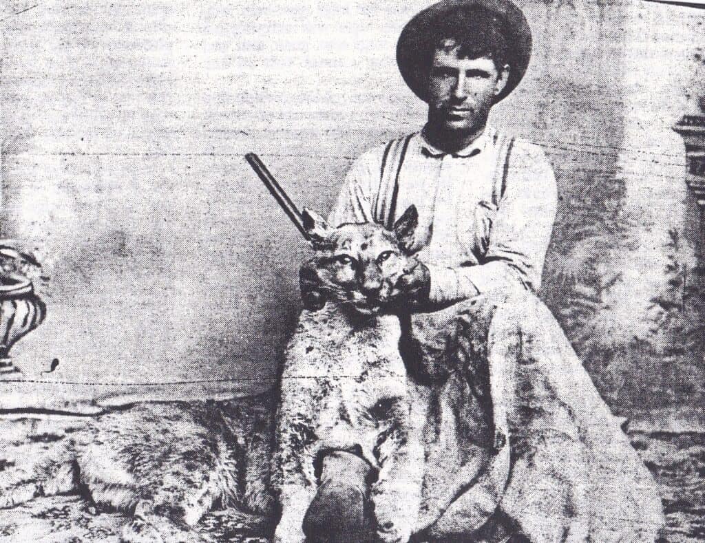 Historical photo of a young boy with a lion, capturing a rare wildlife moment.